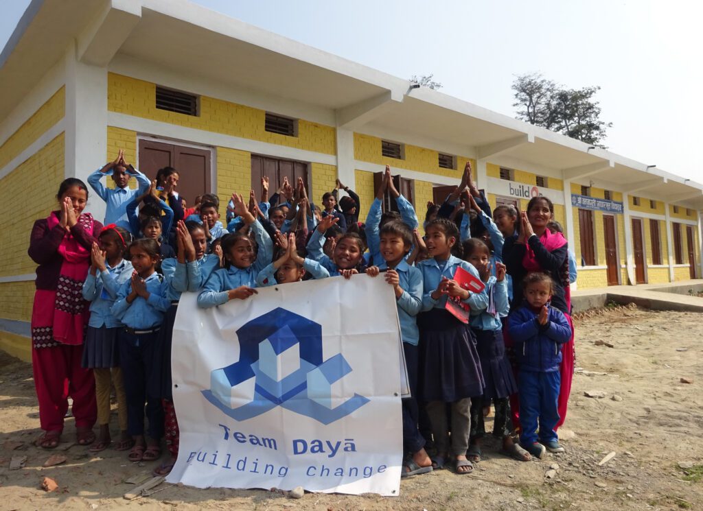 Teachers and students outside the first completed school funded by Team Dayā in Dhayapur, Nepal.